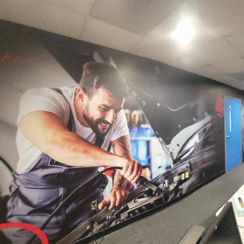 Branded wall wrap of mechanic at Lincoln Tech made by Strategic Factory.