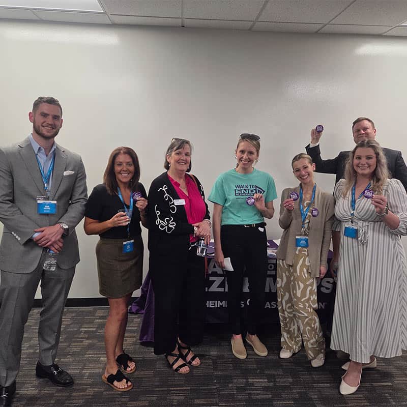 Guests at Strategic Factory networking event posing with promo item.